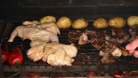 Chef hand using tongs turning raw chicken and beef cuts on charcoal grill r.. Stock Footage 339425219