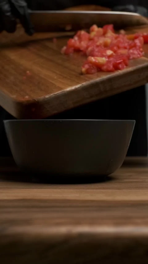 Chef hand wearing black gloves cut red tomato on a wooden board in a kitchen Stock-Footage 283631927