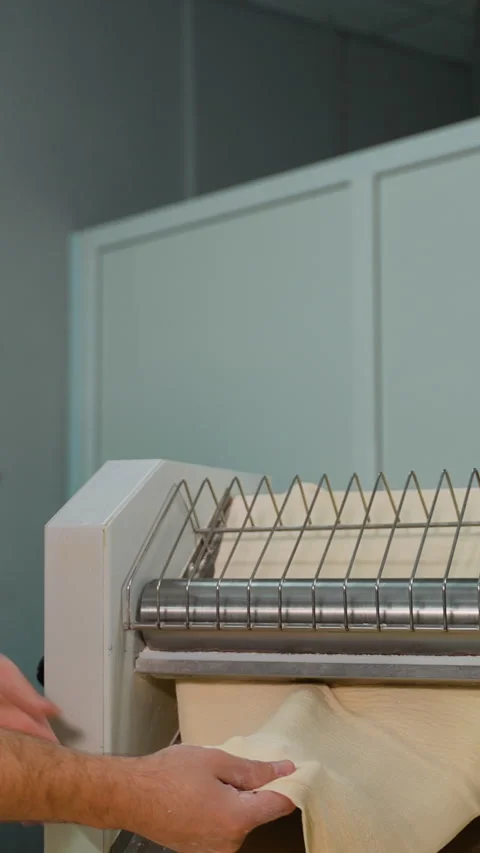 Chef Handling Dough from Sheeter Machine Stock Footage 299657514