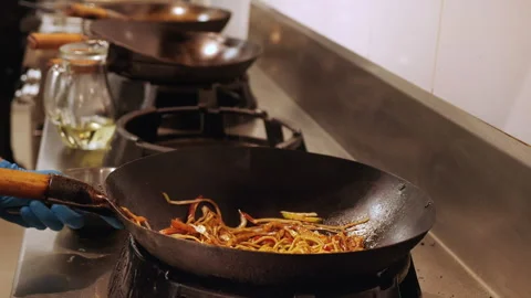 Chef handling the wok preparing a delicious asian meal Video stock 157967726