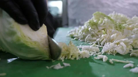 Chef hands in black gloves cutting cabbage thin and fast on a kitchen table Video stock 135256047