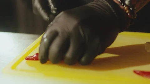 Chef Hands in Black Gloves Slicing Red Chili Pepper and ginger for Garnish Stock Footage 321860682