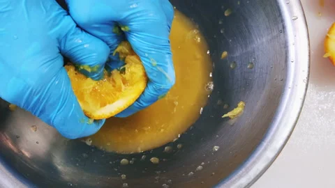 Chef hands in blue gloves press fresh citrus fruit Stock Footage 211357271