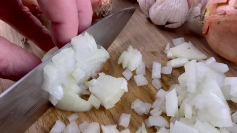 Chef hands chop finely raw onion on wooden cutting board with kitchen knife Video stock 168403955