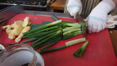 Chef Hands Chopping Fresh Green Onions and Ginger on Cutting Board Video stock 343587934