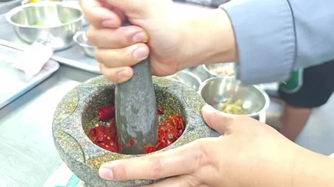 Chef hands crushing red chili in a stone mortar. Vídeo Stock 342392955