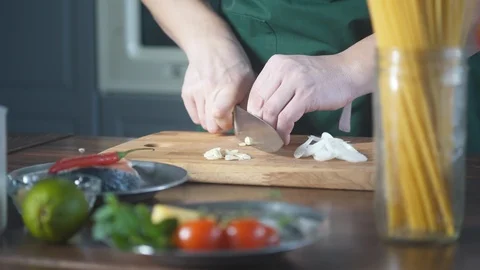 Chef hands cuts onions in restaurant kitchen on wooden cutting board. 스톡 동영상 124709049