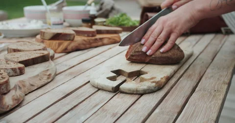 Chef hands cuts pieces of raw bread by professional sharp knife on a wooden 스톡 동영상 144263591