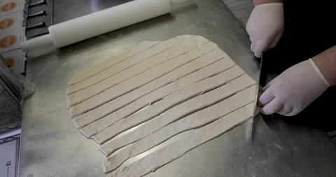 Chef hands cutting dough on metal board Stock Footage 136405774