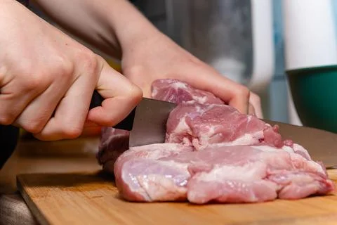 Chef hands cutting large piece of organic raw pork photo 库存照片