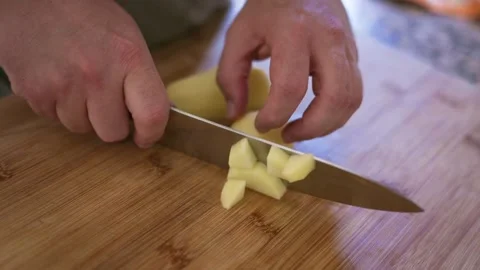 Chef hands cutting a raw potato with knife Stock Footage 335834334