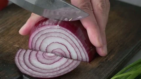 Chef hands cutting red onion with knife on wooden board Stock Footage 226140722
