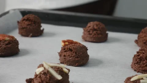 Chef Hands Decorating Chocolate Cookies with Chocolate Chips Stock Footage 329597619