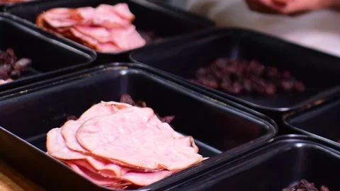 Chef hands distributing food into catering containers shallow focus Vídeo Stock 334686380