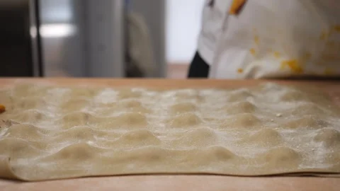 Chef hands dusting fresh homemade pasta dough with flour, preparing traditional Stock Footage 318223142