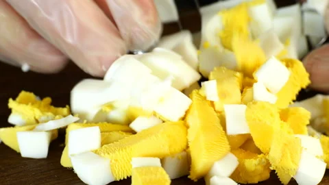 Chef hands finely chopped boiled eggs with metal lattice. Vídeo Stock 131727911