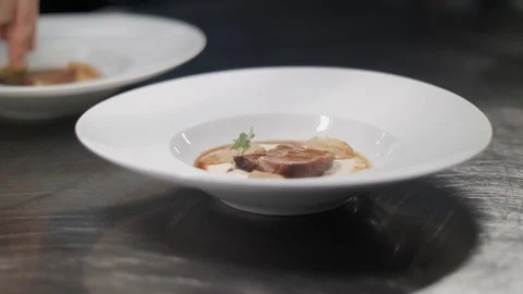 Chef hands finish serving of dishes, sprinkling food with spices. Fresh food on Stock Footage 88674543