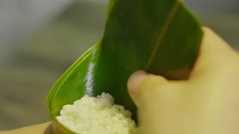 Chef Hands Folding Bamboo Leaf Cone with Glutinous Rice, Close-up Vídeos de archivo 335501452