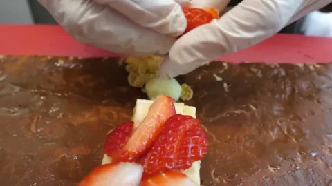 Chef Hands in Gloves Arranging Fresh Strawberry Slices on Dessert Stock Footage 345692154