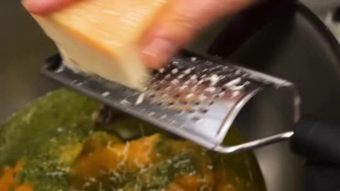 Chef Hands Grating Fresh Parmesan Cheese Over a Pot of Soup Stock Footage 331632675