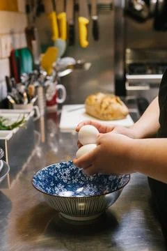 Chef hands holding eggs preparing food in kitchen Stock Photos