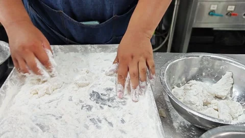 Chef hands holding raw battered fish pieces over a tray. Stock Footage 342739933