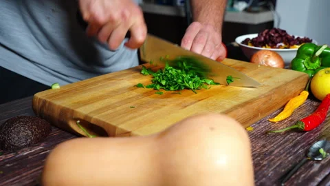 Chef hands in home kitchen cutting up fresh flat parsley on a wooden cuttin.. 库存影片 302303940