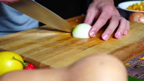 Chef hands in home kitchen cutting an onion bell pepper on a wooden cutting.. Stock Footage 302306555
