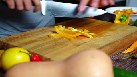 Chef hands in home kitchen cutting an orange bell pepper Stock Footage 302307094