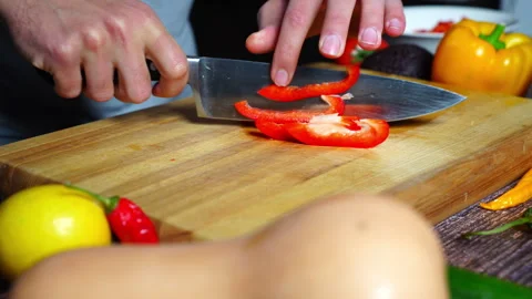 Chef hands in home kitchen cutting red bell pepper on a cutting board Stock Footage 302307325