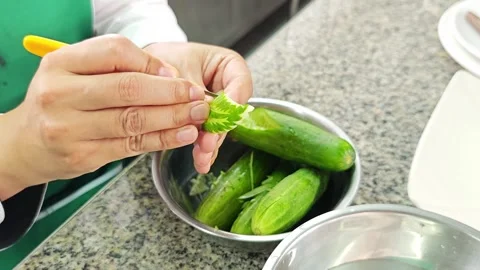 Chef hands intricately carving cucumber into a leaf shape. 库存影片 343697984