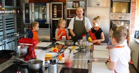 Chef hands out cheese graters to children Stock Footage 139532537