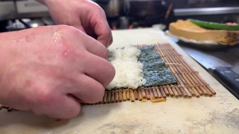Chef hands placing fillings on sushi rice for makizushi roll, izakaya Japan Stock-Footage 343515613