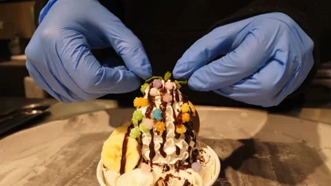 Chef Hands Placing Mint Leaf Garnish on Gourmet Rolled Ice Cream Sundae Stock-Footage 345293246