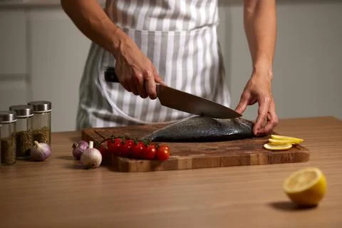 Chef hands preparing fresh fish on cutting board Stock Photos