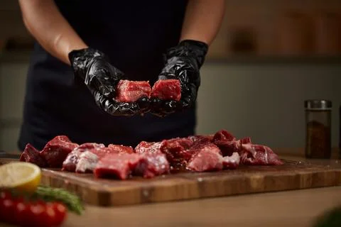 Chef hands preparing raw beef cubes for cooking Stock Photos