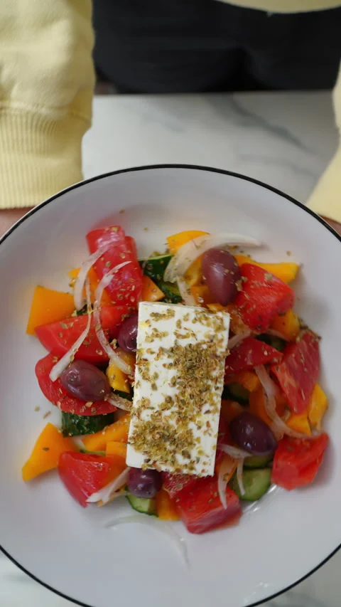 Chef hands presenting mediterranean salad topped with feta, fresh tomatoes Stock Footage 309142135
