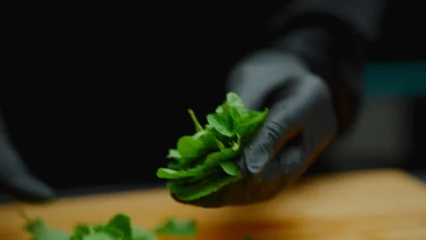 Chef hands processing fresh mint leaves on a wooden board Stock Footage 319745293