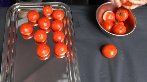 Chef hands put ripe tomatoes vegetables into steel dish. Slow motion shot. Stock Footage 109505979