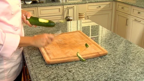 Chef hands rapidly peel and skin cucumber in brightly lit kitchen Stock Footage 123732861