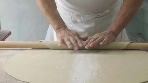 Chef Hands Rolling Fresh Dough with Wooden Rolling Pin on Floured Surface Stock Footage 333523010