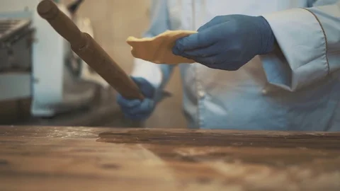Chef hands rolling out butter with rolling pin on wooden table Stock Footage 78024382