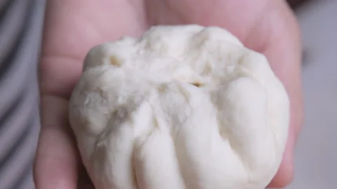 Chef hands shaping the dough with marinated pork chops inside to make a bun. Stock Footage 167781730