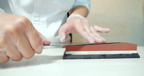 Chef hands sharpening knife. Man hands preparing professional tools Stock Footage 133629219