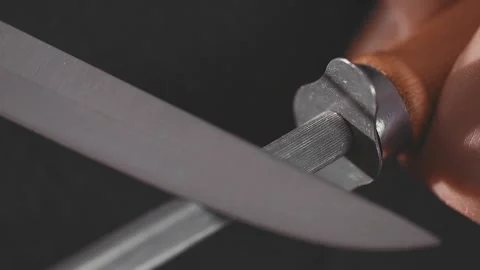 Chef hands sharpening knife in slow motion. Closeup man hands prepare to cook Stock Footage 154730693