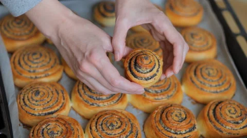 Chef hands show hot fresh roll buns with poppy in the bakery. Close-up. Video stock 101139747