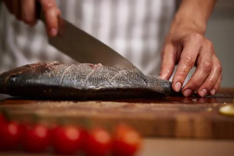 Chef hands slicing fresh fish on cutting board 写真素材