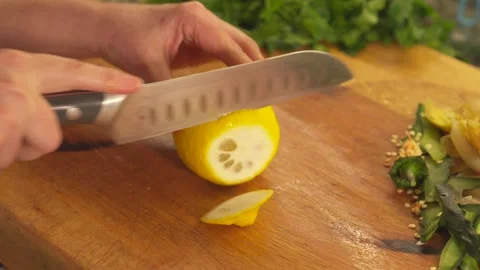 Chef hands slicing a fresh lemon on a wooden cutting board Stock Footage 331314025