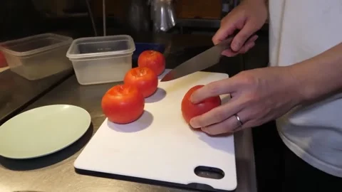 Chef Hands Slicing Fresh Red Tomato on White Cutting Board in Commercial Kitchen Video stock 347689305