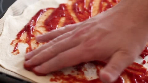 Chef hands is spreading Tomato Sauce on Pizza Dough. Stock Footage 149809843